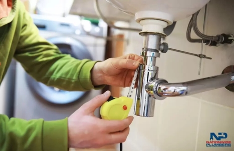 A plumber is fixing a sink.